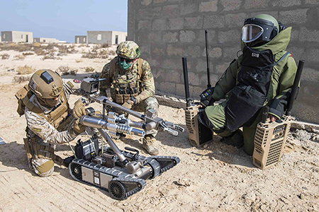 U.S. Navy technicians watch a Saudi sailor connect an explosive tool to a robot during an exercise in Jubail, Saudi Arabia in 2021. The United States is working to persuade countries to adopt a political declaration on the military uses of artificial intelligence, while Austria is advocating a legally binding document.  (Photo by Navy Petty Officer 3rd Class Zachary Pearson)