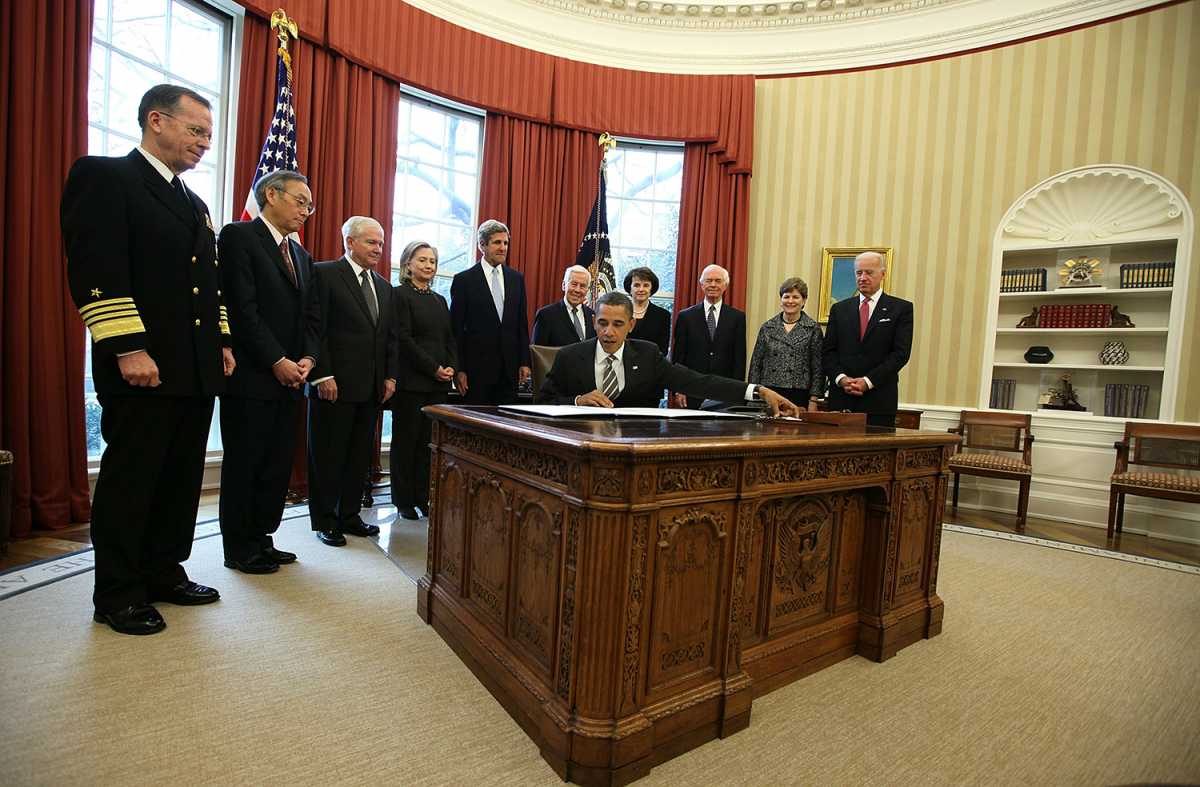 U.S. President Barack Obama signs the New START Treaty into law, as (L-R) Chairman of the Joint Chiefs of Staff Adm. Mike Mullen, Secretary of Energy Steven Chu, Secretary of Defense Robert Gates, Secretary of State Hillary Clinton, Sen. John Kerry (D-Mass.), Sen. Richard Lugar (R-Ind.), Sen. Dianne Feinstein (D-Calif.), Sen. Thad Cochran (R-Miss.), Sen. Jeanne Shaheen (D-N.H.), and Vice President Joseph Biden look on during an Oval Office ceremony February 2, 2011 in Washington. Credit: Alex Wong/Getty Images