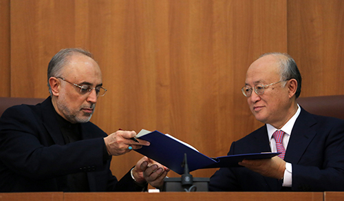 Ali Akbar Salehi (left), head of the Atomic Energy Organization of Iran, and Yukiya Amano, director-general of the International Atomic Energy Agency, sign an agreement in Tehran on November 11, 2013, on the agency’s investigation into past Iranian activities suspected of being part of an effort to develop nuclear weapons. (Atta Kenare/AFP/Getty Images)