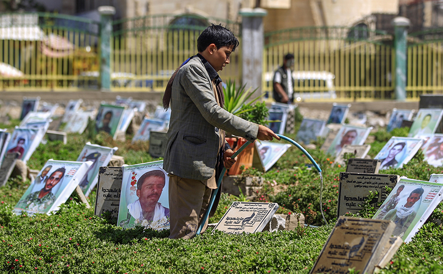 A Yemeni boy waters plants and cleans tombstones in a Sanaa cemetery in March.  More than 17,000 civilians have died in the fighting that began in 2015, according to the Office of the UN High Commissioner for Human Rights. (Photo: Mohammed Hawais/AFP/Getty Images)