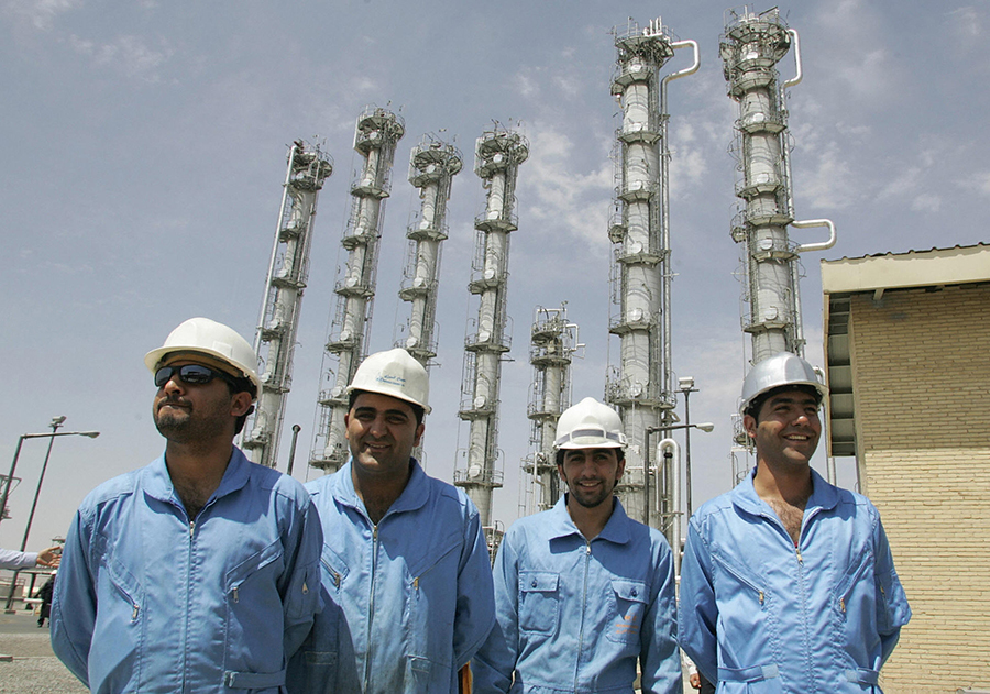 Iranian workers smile at the nation’s newly opened heavy water production plant in Arak in 2006. Iran has moved closer to storing more heavy water than allowed by the 2015 nuclear deal. (Photo: Atta Kenare/AFP/Getty Images)