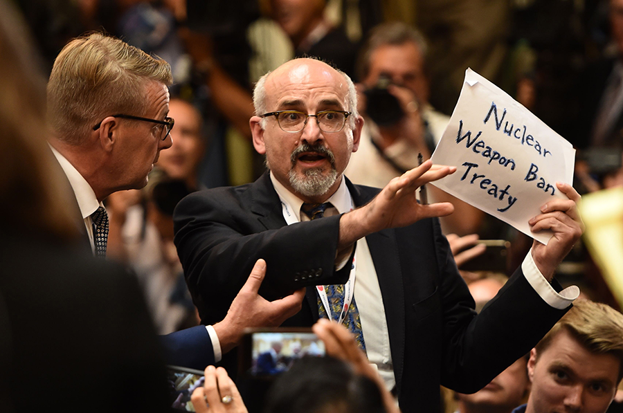 A protestor is escorted from a U.S.-Russian presidential press conference in July 2018. The 2017 Treaty on the Prohibition of Nuclear Weapons has challenged nuclear-weapon states to advance nuclear disarmament. (Photo: Brendan Smialowski/AFP/Getty Images)