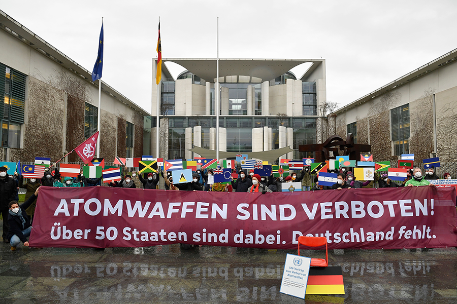 Anti-nuclear activists of the International Campaign to Abolish Nuclear Weapons and other peace initiatives protest with the 51 flags of countries that ratified the Treaty on the Prohibition of Nuclear Weapons (TPNW) in front of the German Chancellery in Berlin on January 22. Their banner reads: “Nuclear weapons are forbidden!” (Photo by Tobias Schwarz/AFP via Getty Images)