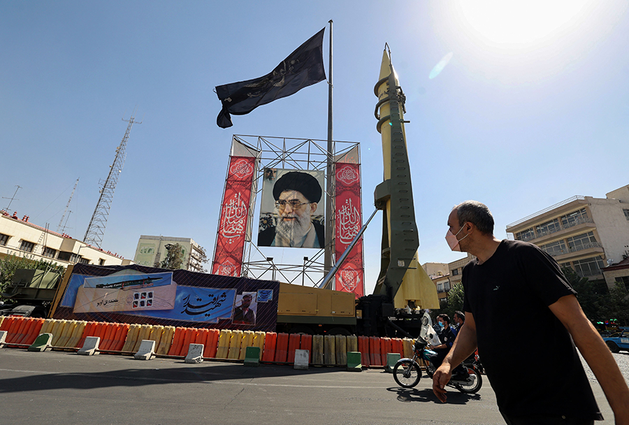 A Shahab-3 surface-to-surface missile is displayed in Tehran next to a portrait of Iranian Supreme Leader Ayatollah Ali Khamenei at a 2021 exhibition marking the 1980–88 Iran-Iraq war. (Photo by Atta Kenare/AFP via Getty Images)
