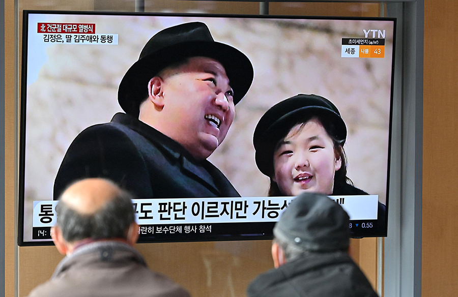 North Korean leader Kim Jong Un (L) and his daughter are seen on television in South Korea (R) attending a military parade showcasing nuclear and intercontinental ballistic missiles in Pyongyang in February. U.S. intelligence reports increasing signs that Pyongyang may test a nuclear weapon. (Photo by Jung Yeon-Je/AFP via Getty Images)