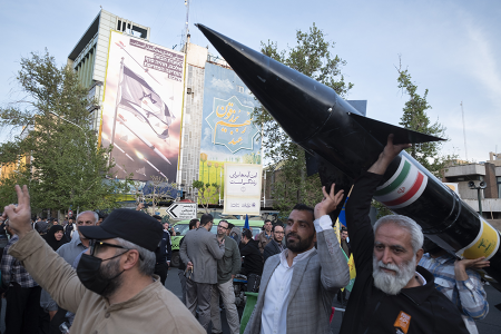 Unidentified men in Tehran carry a model of Iran’s first-ever hypersonic missile, Fattah, past an anti-Israeli mural during a gathering on April 15 to celebrate Iran’s drone and missile attack against Israel in retaliation for Israel’s attack on Iran’s consulate in Damascus. (Photo by Morteza Nikoubazl/NurPhoto via Getty Images)