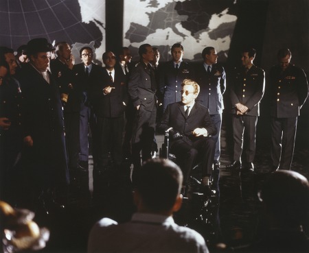 Peter Sellers, seated, as Dr. Strangelove, is surrounded by generals in a ‘war room’ scene from the 1964 pathbreaking classic movie satire Dr. Strangelove or How I Learned to Stop Worrying and Love the Bomb. (Photo by Screen Archives/Getty Images)