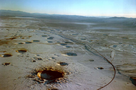 Aerial view of Yucca Flat looking south. In the foreground is Sedan Crater. Measuring 320 feet in depth, it is the deepest crater on the Nevada Test Site. (Photo courtesy of U.S. Department of Energy.)