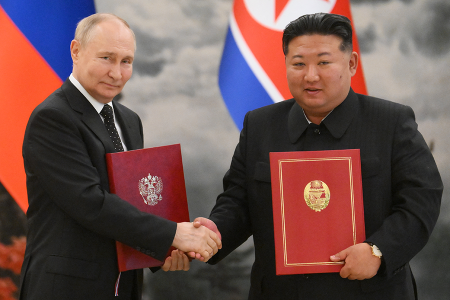 Russian President Vladimir Putin (L) and North Korean leader Kim Jong Un shake hands after signing a mutual defense treaty in Pyongyang on June 19. (Photo by Kristina Kormilitsyna / POOL / AFP via Getty Images, distributed by Sputnik, the Russian state agency) 