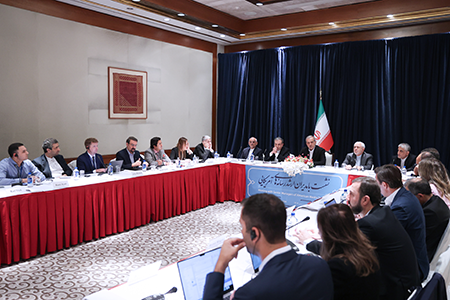 Iranian President Masoud Pezeshkian (in front of flag), flanked by advisers, meets journalists during his first visit to New York for the UN General Assembly since winning election in July. (Photo by Iranian Presidency / Handout/Anadolu via Getty Images)