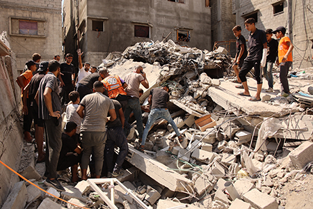 Palestinians search for survivors amid the rubble of a building that collapsed after an Israeli bombardment struck an adjacent structure on Sept. 23 in Gaza City.  (Photo by Omar Al-Qattaa/AFP via Getty Images)