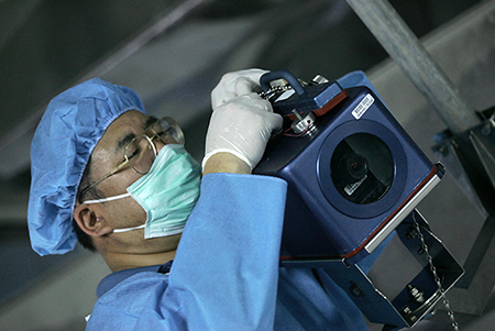 An unidentified inspector of the International Atomic Energy Agency (IAEA) installs a camera at Iran’s Isfahan Uranium Conversion Facilities, south of Tehran, in 2005. The camera is one of the devices that the IAEA uses to keep track of Iran's nuclear activities. (Photo by Behrouz Mehri/AFP via Getty Images)
