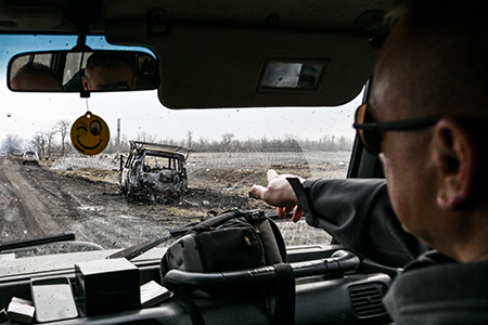 A Ukrainian soldier points at a burnt-out car that caught fire March 19 in a Russian drone strike. Russia’s war against Ukraine is expected to continue to be a contentious issue at the nuclear Nonproliferation Treaty Review Conference that begins April 27 in New York. (Photo by Dmytro Smolienko/ Ukrinform/Future Publishing via Getty Images)