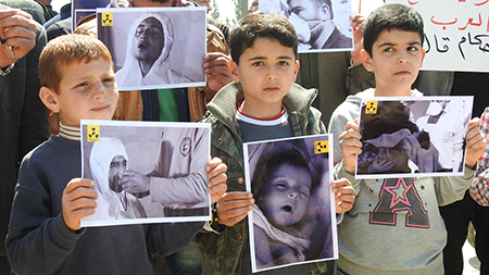 Survivors of a chemical gas attack gather to protest the regime of Syrian President Bashar al-Assad at the Khan Shaykhun town square in Idlib, Syria, in April 2017. With Assad now ousted, the successor government began destroying the country’s chemical weapons arsenal in 2026. (Photo by Firas Faham/Anadolu Agency/Getty Images)