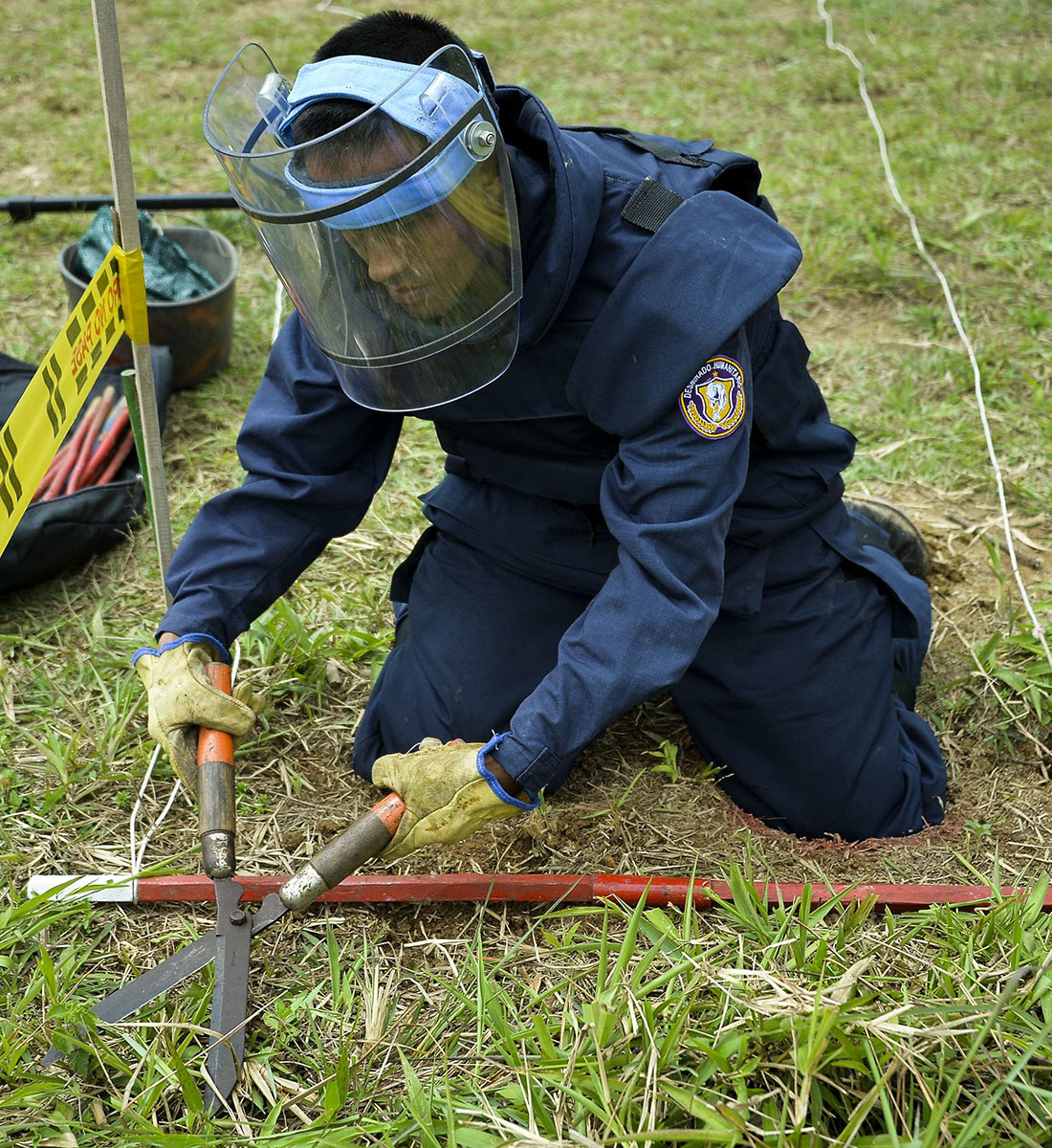 A soldier practices with a fake mine before engaging in humanitarian demining efforts, in Campo Alegre in Colombia. Assisting impacted communities is a core humanitarian disarmament approach. (Photo: RAUL ARBOLEDA/AFP via Getty Images).