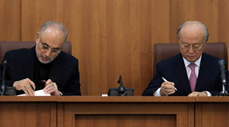 Ali Akbar Salehi (left), the head of the Atomic Energy Organization of Iran, and Yukiya Amano, director-general of the IAEA, sign a framework agreement in Tehran on November 11, 2013. (Photo: Atta Kenare/AFP/Getty Images)