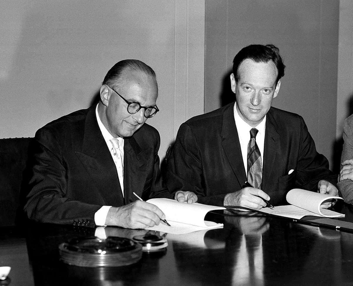 Franz Matsch, Austria’s permanent representative to the UN and Paul Robert Jolles, executive secretary of the 18-nation Preparatory Commission for the International Atomic Energy Agency (IAEA), sign a conference agreement to secure facilities for the first General Conference of the IAEA on July 24, 1957 in Vienna. (UN Photo/MB)